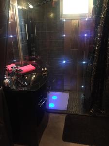 een badkamer met een zwarte wastafel en een douche met een aansluiting bij Gîte 2 personnes pour une nuit en amoureux in Saint-Brevin-les-Pins