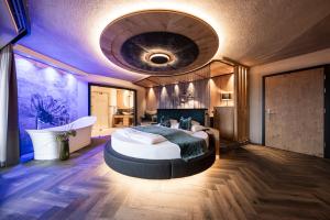 a large bedroom with a large bed and a bath tub at DER MESNERWIRT - 4 Superior - Meraner Land in Avelengo