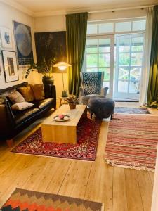 een woonkamer met een bank en een salontafel bij Smukt, sjælfuldt og charmerende hus midt i Odense. in Odense