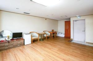 an empty room with a table and chairs and a television at Jeju Royal Hotel in Jeju