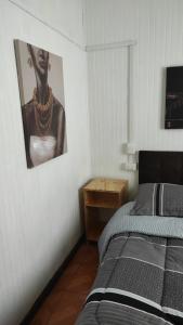 a bedroom with a bed and a picture of a woman at Cabañas y hostal sol de oriente in Puerto Montt