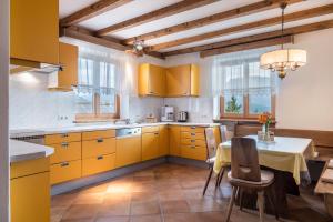 una cocina con armarios amarillos y una mesa con sillas en Apartment Funtnatsch, en Laion