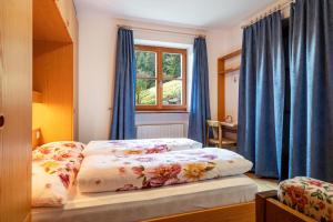 a bedroom with two beds with blue curtains and a window at Apartment Funtnatsch in Laion