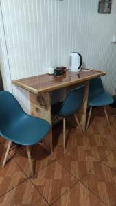 プエルトモントにあるCabañas y hostal sol de orienteの木製テーブル(青い椅子2脚、テーブル付)