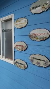 una pared con carteles en una pared azul con una ventana en Cabañas y hostal sol de oriente en Puerto Montt