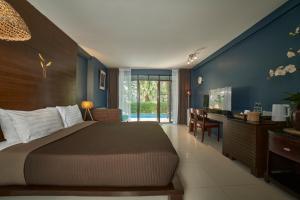 a bedroom with a bed and a desk and a sink at The Bihai Hua Hin in Hua Hin