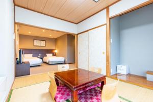 Hakone Forest of Verde في هاكوني: غرفة نوم مع مكتب وغرفة نوم مع سريرين