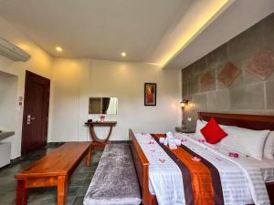 a hotel room with a bed and a bench in it at The Palmery in Siem Reap