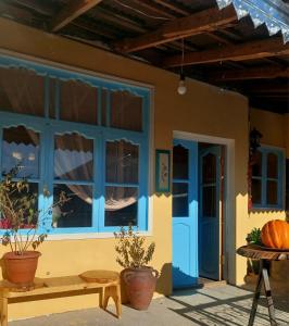 una casa con una ventana azul y un banco en Guest House Ruh Achari, en Sheki