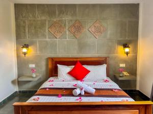 a bedroom with a bed with red pillows at The Palmery in Siem Reap