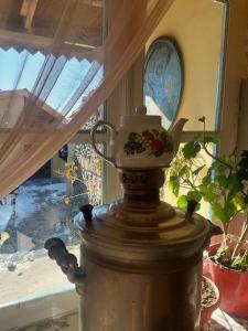 a tea pot sitting on top of a table next to a window at Guest House Ruh Achari in Sheki