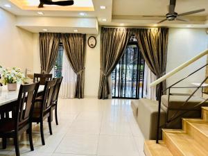 een woonkamer met een tafel en stoelen en een klok bij FamilyHaven at Presint 18 by Elitestay [5Rooms] in Putrajaya