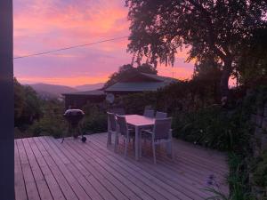 een tafel en stoelen op een terras met een grill bij Jay's Snug in Knysna