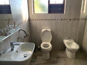 een badkamer met een wit toilet en een wastafel bij Jay's Snug in Knysna