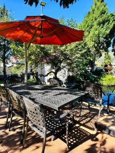 een tafel en stoelen met een rode parasol bij Mongo Garden in Da Lat