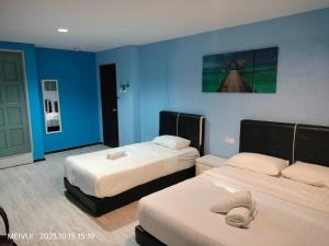 two beds in a room with blue walls at May Room Semporna in Semporna
