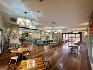 - un restaurant avec des tables et des chaises dans une salle dans l'établissement Livingston Hotel, à Sandakan