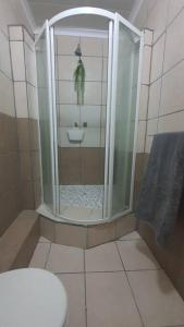 a bathroom with a shower with a toilet and a sink at Stay at the Ridge in Bloemfontein