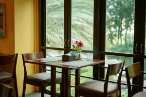 uma mesa e cadeiras num quarto com uma janela em The Bihai Hua Hin em Hua Hin