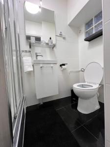 a white bathroom with a toilet and a sink at Aéroport CDG Bourget Expo Astérix Paris Disney in Gonesse