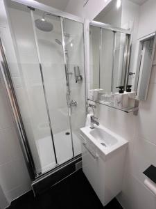 a white bathroom with a shower and a sink at Aéroport CDG Bourget Expo Astérix Paris Disney in Gonesse