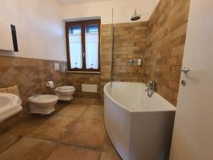 y baño con bañera, aseo y lavamanos. en Villa Malvasio Retreat & Spa en Sassari