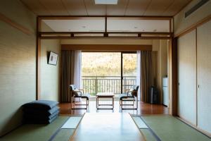 Hotel Harvest Kinugawa في نيكو: غرفة معيشة مع طاولة وكراسي وشرفة