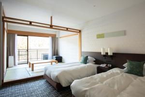 a hotel room with two beds and a balcony at Hotel Harvest Kinugawa in Nikko
