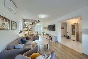 a living room with two couches and a living room with a tv at Villa Parlera in Ližnjan