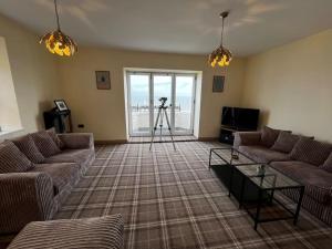 uma sala de estar com dois sofás e uma câmara em Luxury Penthouse Apartment em Lowestoft