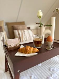 a table with a tray with bread and an egg and a drink at B&B Giethoorn in Giethoorn