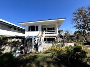 a white house with a staircase leading to it at Bobby's Villa Beachfront, Bauang in Bauang