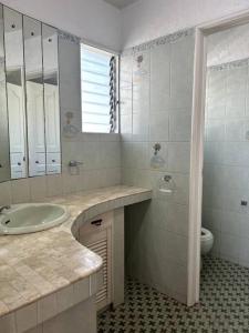 a bathroom with a sink and a toilet at Bobby's Villa Beachfront, Bauang in Bauang