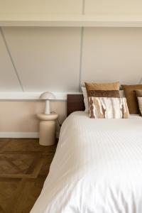 Un dormitorio con una gran cama blanca y una lámpara en B&B Giethoorn en Giethoorn