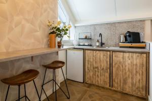 a kitchen with wooden cabinets and two stools at B&B Giethoorn in Giethoorn