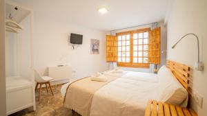 a bedroom with a bed and a desk and a window at Carmen San Luis Albaicin, Granada in Granada