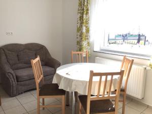 sala de estar con mesa, sillas y sofá en Lamar Apartman, en Kapuvár