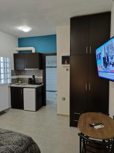 a living room with a table and a kitchen at GM 7 ROOMS KENTRO στην καρδιά της πόλης in Larisa