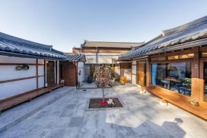 a house with a patio with a tree in the middle at And spring in Jeonju