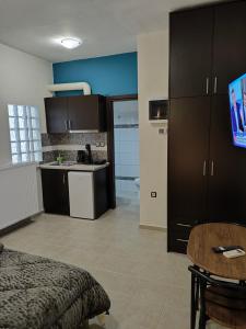 a room with a bed and a kitchen with a table at GM 7 ROOMS KENTRO στην καρδιά της πόλης in Larisa