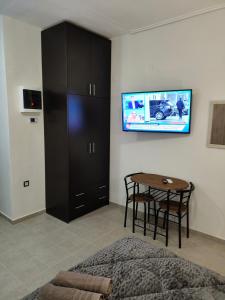 a bedroom with a table and a tv on a wall at GM 7 ROOMS KENTRO στην καρδιά της πόλης in Larisa