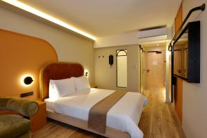 1 dormitorio con 1 cama blanca grande y 1 sofá en City Lodge Hotel V&A Waterfront en Ciudad del Cabo