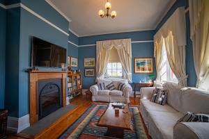 a living room with blue walls and a fireplace at Poet's Cottage Stanley in Stanley