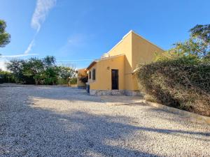 a yellow house with a driveway in front of it at CASA FORTUNATA in Benitachell