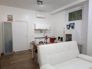 een woonkamer met een witte bank en een keuken bij Lovely Apartment Piatti Duomo in Milaan