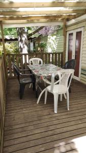 un patio con mesa y sillas en una terraza en MOBIL HOME CAMPING 3***, en Villefranche-de-Conflent