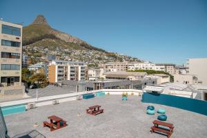 a patio with picnic tables and a view of a city at Mojo Hotel & Market in Cape Town