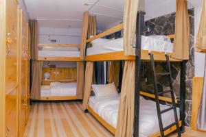 um quarto com três beliches numa casa em Roamers Inn em Pokhara
