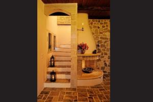 a staircase in a home with a stone wall at Πέτρινο Σπίτι με Θέα Θάλασσα in Achlia