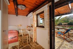 a bedroom with a bed and a desk and a window at Πέτρινο Σπίτι με Θέα Θάλασσα in Achlia